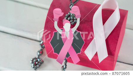 Image of woma in boxing gloves icon over pink box and ribbon on white wooden background Image of woma in boxing gloves icon over pink box and ribbon on white wooden background 87071605