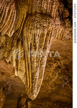 Clouse up of ripples in stalactite of cave stuck to ceiling Clouse up of ripples in stalactite of cave stuck to ceiling 87073263