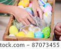 Asian child girl touching tiny bunny with tenderness and love. Baby rabbits in the nest with mommy fur and hay. People take care a pet and decorate home for Easter. Happy Easter Happy holiday. 87073455