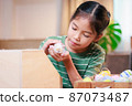 Asian child girl holding tiny bunny in hand with tenderness and love. Kid take care a pet and decorate home for Easter. Happy Easter Happy holiday. 87073487