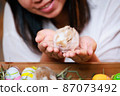 Asian woman holding tiny bunny in hand with tenderness and love. People take care a pet and decorate home for Easter. Happy Easter Happy holiday. 87073492