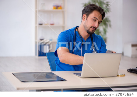 Young male doctor working in the clinic 87073684