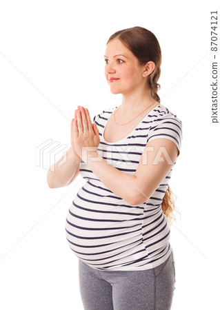 Pregnant woman doing yoga asana asana Tadasana namaste -Mountain pose with salutation 87074121