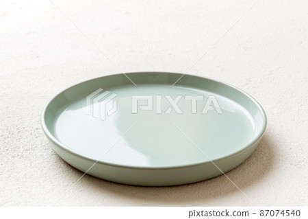 Perspective view of empty blue plate on cement background. Empty space for your design 87074540