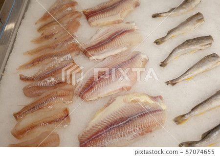 Fresh sea fish in ice on the counter of the store store or at the market. Fresh sea fish in ice on the counter of the store store or at the market. Shop window with fish products. Fresh sea fish in ice on the counter of the store store or at the market. Fresh sea fish in ice on the counter of the store store or at the market. Shop window with fish products. 87074655