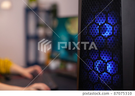 Closeup of RGB led lights powerful computer, woman gamer playing space shoother videogames Closeup of RGB led lights powerful computer, woman gamer playing space shoother videogames 87075310