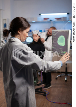 Neurologist specialist analyzing nervous system tomography on monitor Neurologist specialist analyzing nervous system tomography on monitor 87075340