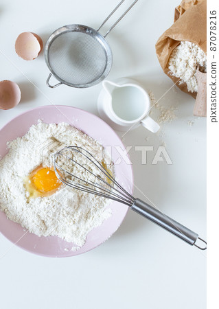 Preparing dough for baking top view on white table with ingredients and tools. Preparing dough for baking top view on white table with ingredients and tools. 87078216