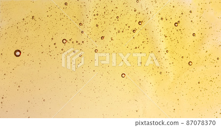 Texture of oil or face serum closeup. Abstract cosmetics oil background. Texture of oil or face serum closeup. Abstract cosmetics oil background. 87078370