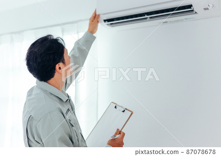 一名穿著工作服的男子檢查空調和空調設備(後視圖) 一名穿著工作服的男子檢查空調和空調設備(後視圖) 87078678