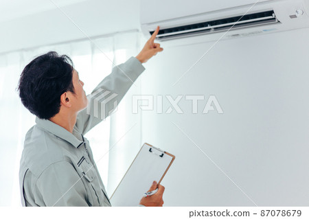 A man in work clothes checking air conditioners and air conditioning equipment (back view) A man in work clothes checking air conditioners and air conditioning equipment (back view) 87078679