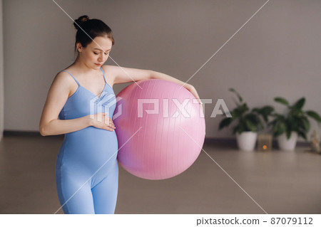 Pregnant woman during fitness classes with a fitball 87079112