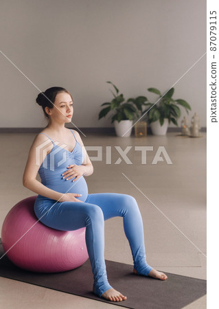 Pregnant woman during fitness classes with a fitball 87079115