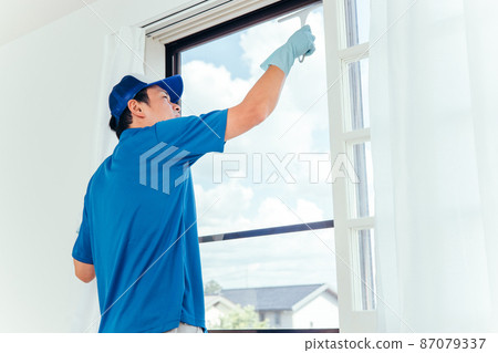 Men in work clothes cleaning windows 87079337