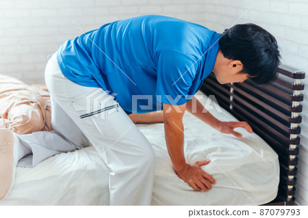 Men in work clothes making beds and cleaning rooms 87079793
