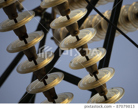 High Voltage electric wires cap and pin insulator detail on blue sky 87079813