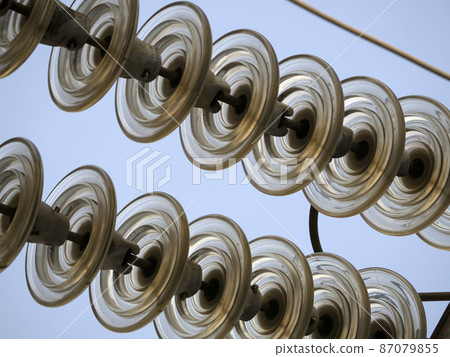 High Voltage electric wires cap and pin insulator detail on blue sky High Voltage electric wires cap and pin insulator detail on blue sky 87079855