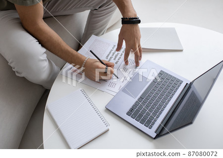 Hands of young economist with pen pointing at financial document 87080072