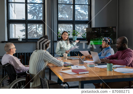 Young Asian businesswoman pointing at interactive screen with graph Young Asian businesswoman pointing at interactive screen with graph 87080271