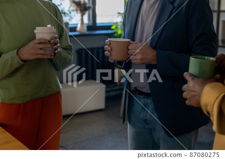 Group of elegant office workers having drinks and talking at break 87080275