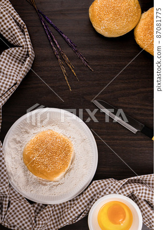 bread concept buns, a dish of flour, a knife, and a tiny bowl of raw egg lying on the dark wooden table bread concept buns, a dish of flour, a knife, and a tiny bowl of raw egg lying on the dark wooden table 87081775