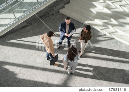 Group of contemporary delegates in formalwear having discussion Group of contemporary delegates in formalwear having discussion 87081846