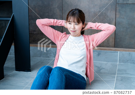 在客廳做腹肌訓練的年輕女子 87082737