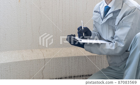 Workers inspecting deterioration and cracks on the outer wall Workers inspecting deterioration and cracks on the outer wall 87083569