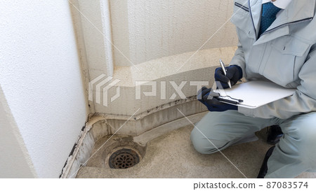 Workers inspecting deterioration of outer walls and clogging of drains 87083574