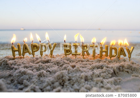 Candles Gold Letters Happy Birthday Burning on Background of Blurry Sea Waves 87085800
