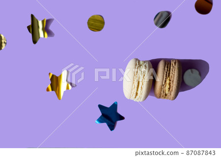 christmas gift set. vanilla macaroons. assorted cakes. Ordering desserts. cakes and confetti. lavender background. color of the year very peri 87087843