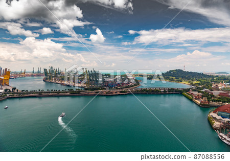 The huge busiest logistic port in Singapore, plenty of cranes to move containers, huge cargo ships in the background, shopping malls and skyscrapers surrounded by, entertainment island nearby The huge busiest logistic port in Singapore, plenty of cranes to move containers, huge cargo ships in the background, shopping malls and skyscrapers surrounded by, entertainment island nearby 87088556