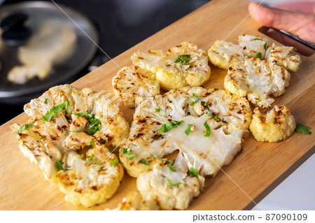 Cauliflower steak with spices cooks close-up. Selective focus 87090109