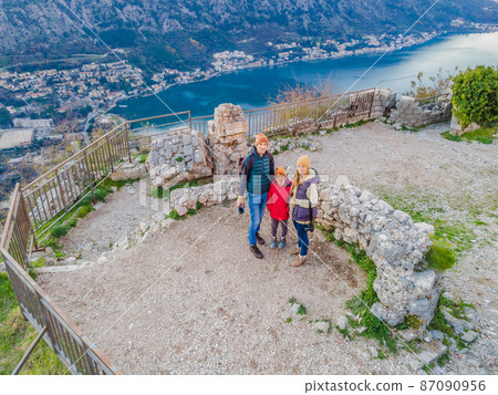 Family of hikers on Hiking in Kotor Old Town Ladder of Kotor Fortress Hiking Trail. Aerial drone view Family of hikers on Hiking in Kotor Old Town Ladder of Kotor Fortress Hiking Trail. Aerial drone view 87090956