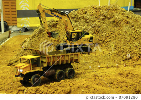 SELANGOR, MALAYSIA - MARCH 16, 2021: Selected focused on remote control construction machinery toys. Placed inside the game set seems to be on an actual construction site. 87091280