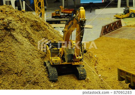 SELANGOR, MALAYSIA - MARCH 16, 2021: Selected focused on remote control construction machinery toys. Placed inside the game set seems to be on an actual construction site. 87091283