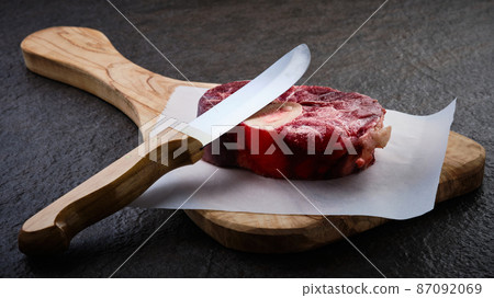 Osso buco steak on wooden cutting board 87092069