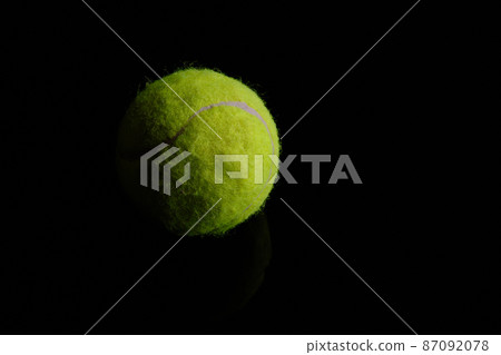 Green tennis ball at black background Green tennis ball at black background 87092078