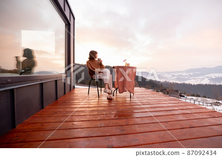 Woman resting at small house in the mountains 87092434