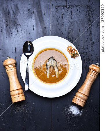 Wooden pepperbox, saltcellar and spoon near dish. Wooden pepperbox, saltcellar and spoon near dish. 87092539