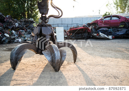 Large tracked excavator working a steel pile at a metal recycle yard. Industrial scrap metal recycling - selective focus, copy space Large tracked excavator working a steel pile at a metal recycle yard. Industrial scrap metal recycling - selective focus, copy space 87092871