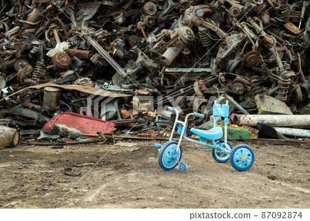 Large tracked excavator working a steel pile at a metal recycle yard. Industrial scrap metal recycling - selective focus, copy space Large tracked excavator working a steel pile at a metal recycle yard. Industrial scrap metal recycling - selective focus, copy space 87092874