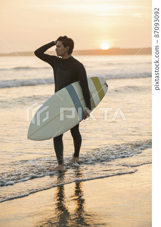 A man surfing in the morning sea A man surfing in the morning sea 87093092