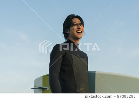 A man surfing in the morning sea 87093295