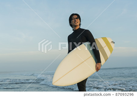 A man surfing in the morning sea 87093296