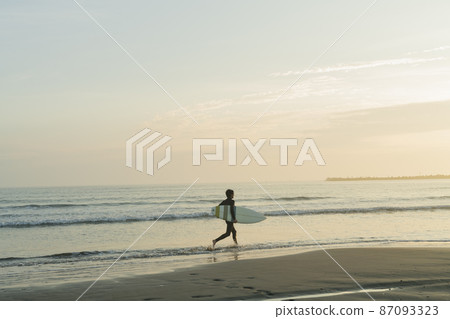 A man surfing in the morning sea A man surfing in the morning sea 87093323