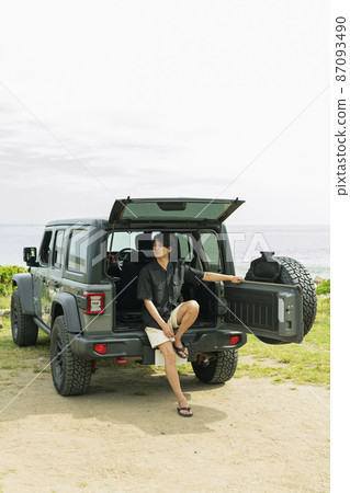 Man sitting in the trunk of a car Man sitting in the trunk of a car 87093490