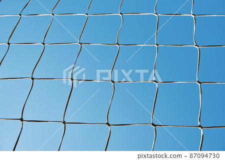Soccer or football cage texture against blue sky 87094730