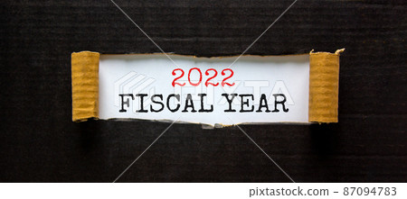2022 fiscal new year symbol. Words '2022 fiscal year' appearing behind torn black paper. Beautiful black background. Business, 2022 fiscal new year concept, copy space. 2022 fiscal new year symbol. Words '2022 fiscal year' appearing behind torn black paper. Beautiful black background. Business, 2022 fiscal new year concept, copy space. 87094783