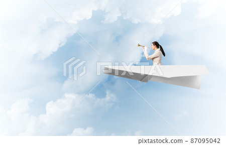 Elegant woman playing trumpet brass 87095042